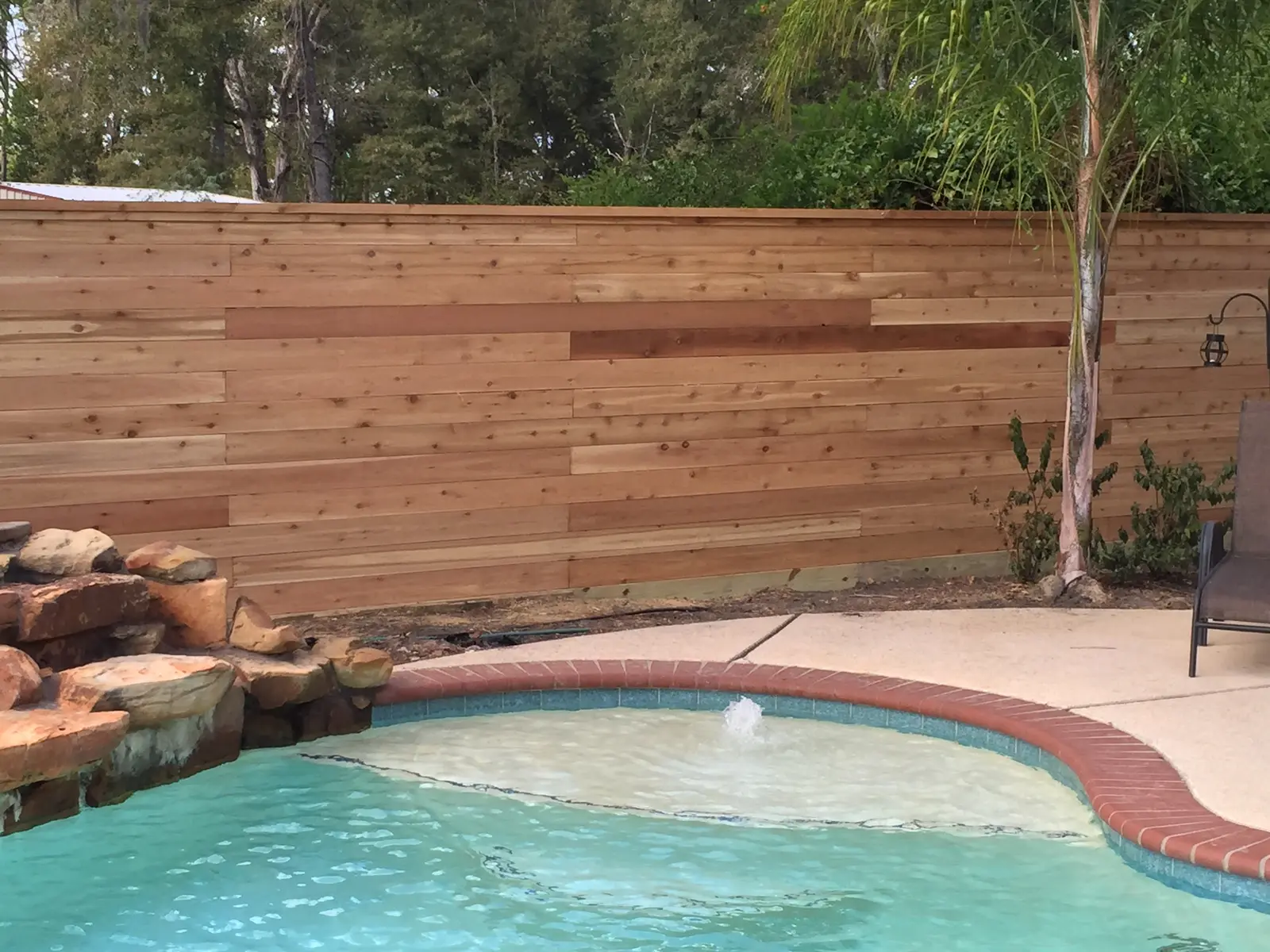 Horizontal cedar privacy fence along a backyard pool
