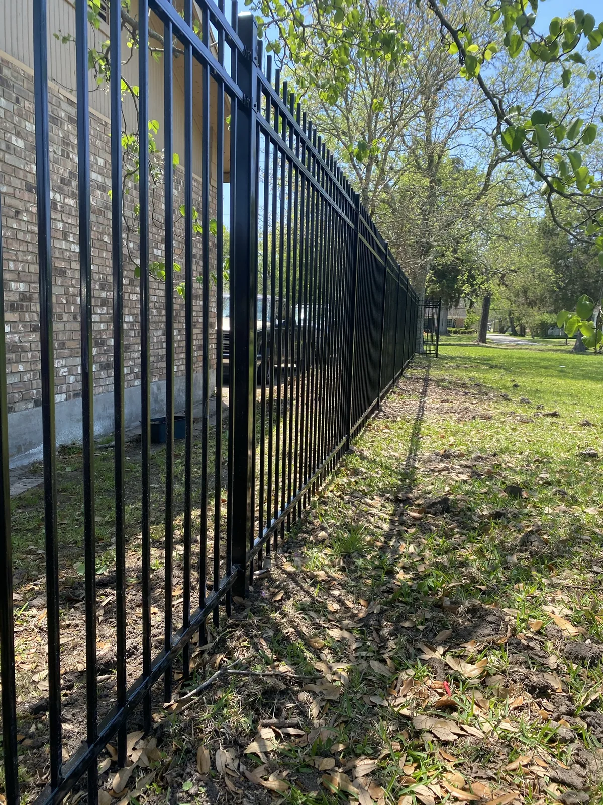 Black ornamental aluminum fence along a property line
