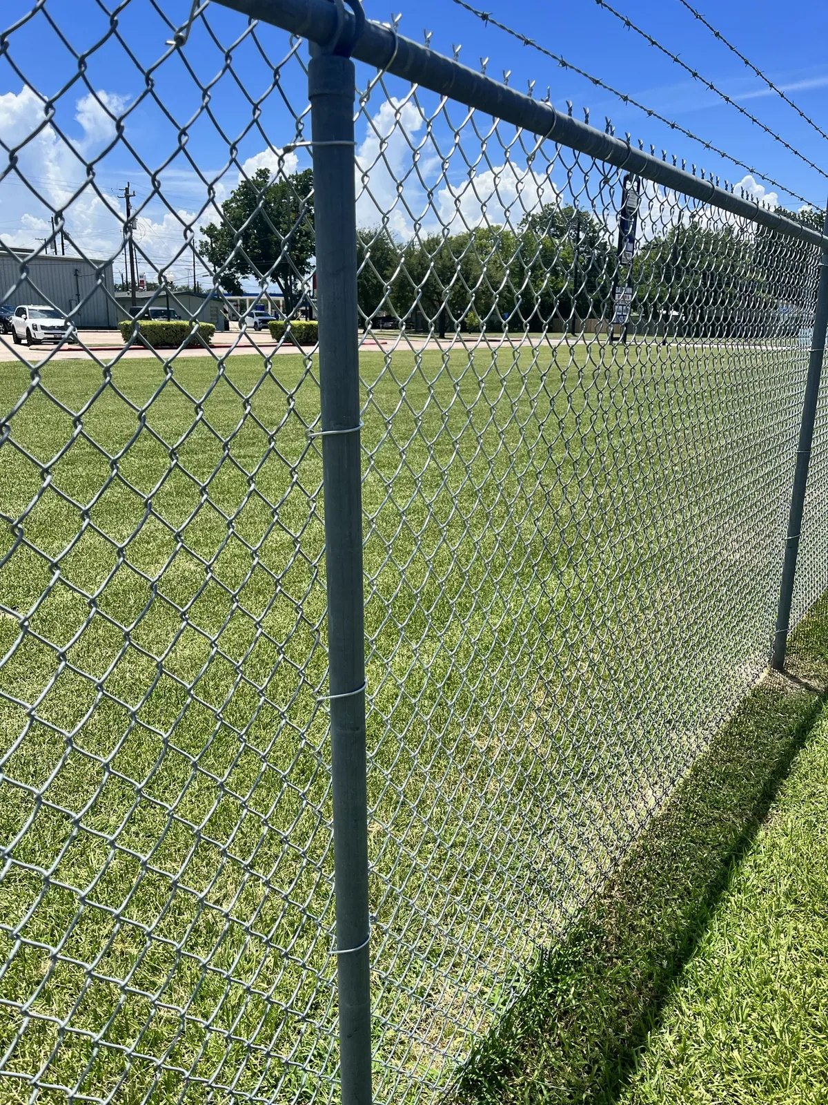 Galvanized chain link security fencing with barbed wire above the top rail