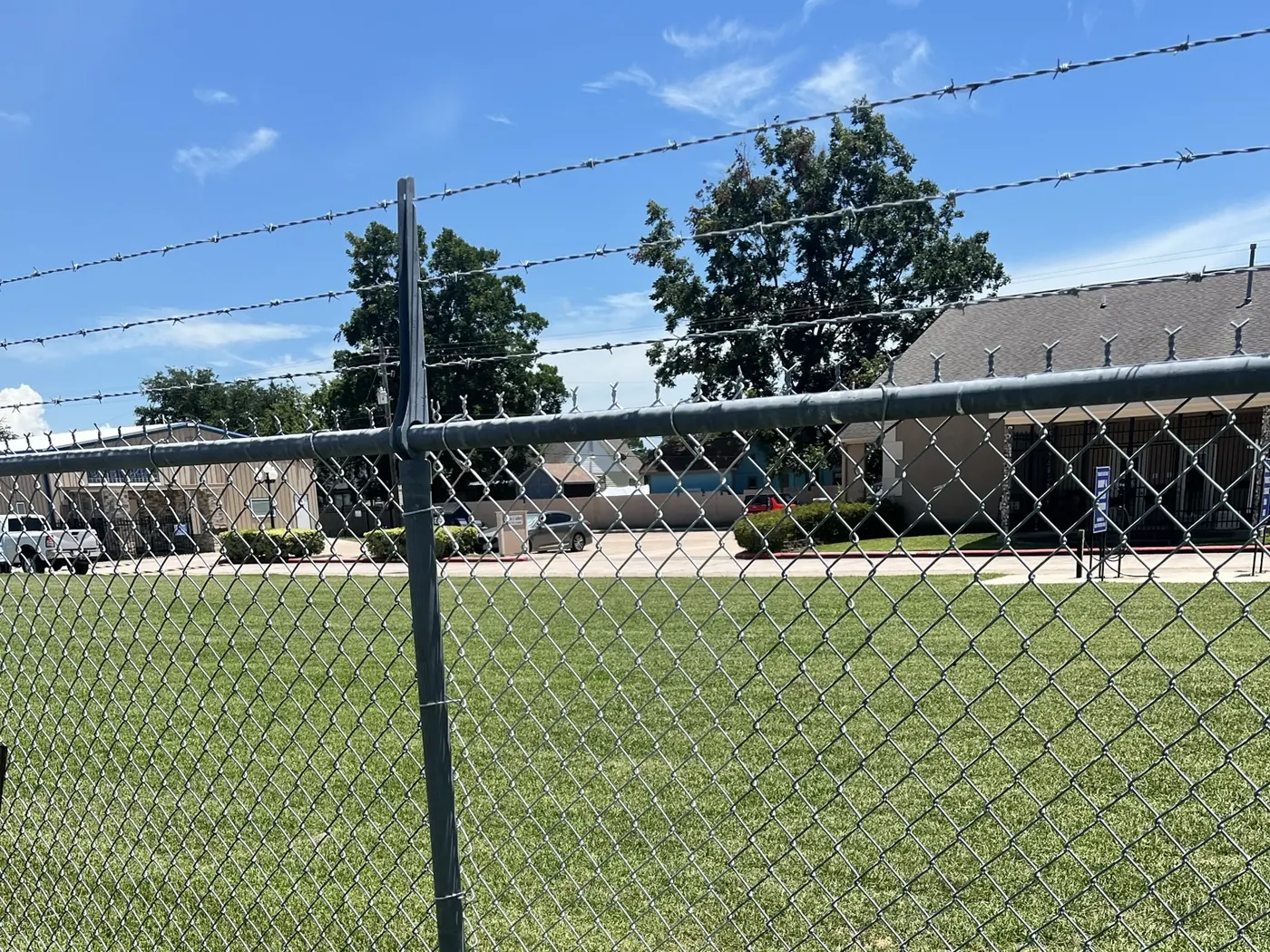Galvanized chain link security fencing with barbed wire above the top rail
