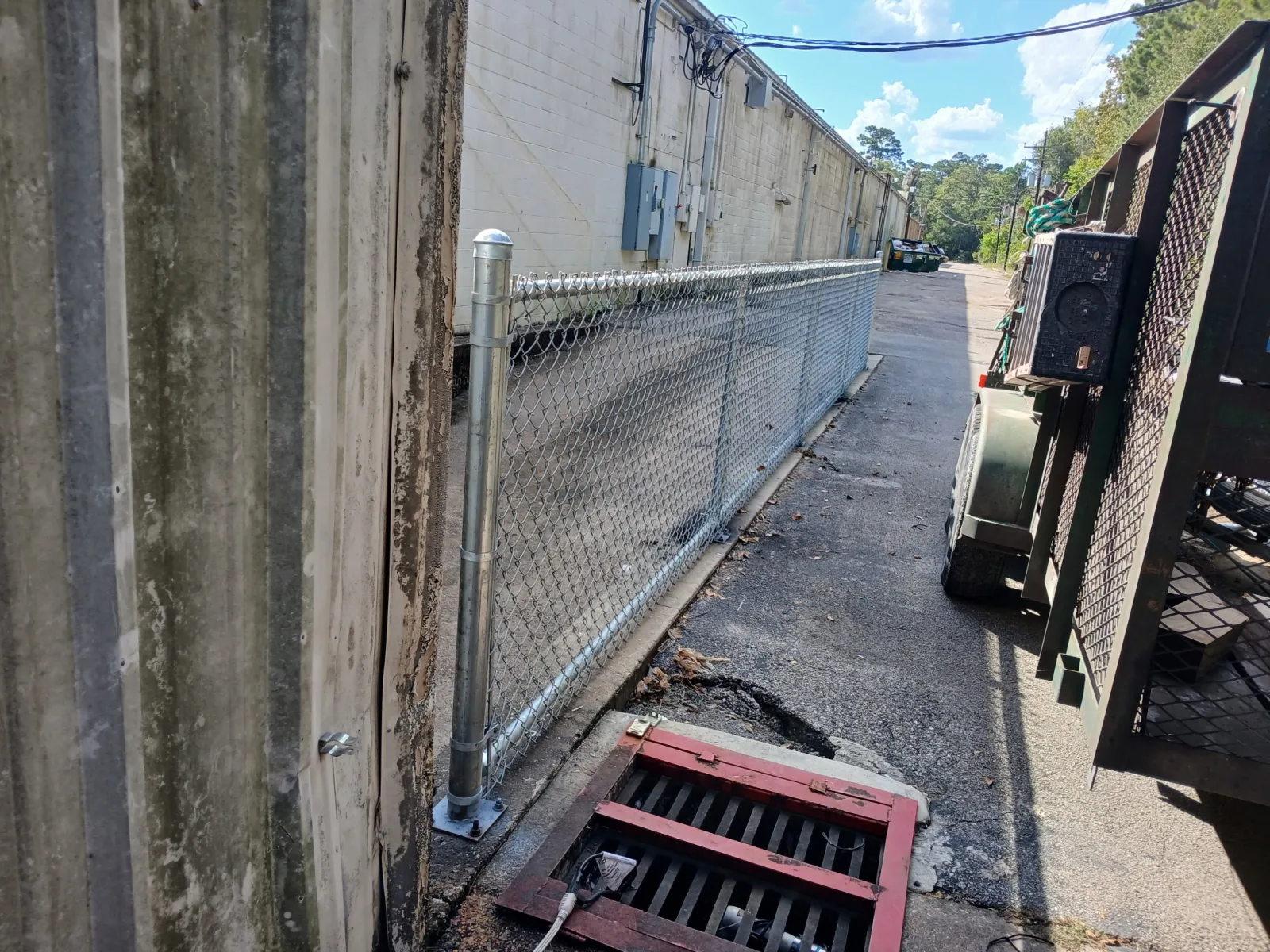 Galvanized chain link perimeter fencing down a service alley