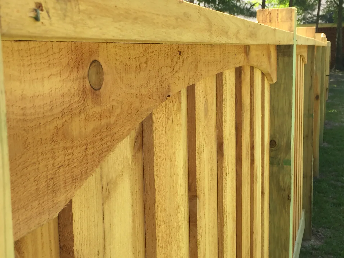 Wood gate frame with a cap rail and diagonal brace, the parts a gate repair replaces